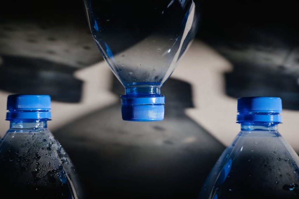 Artistic close-up of plastic bottles casting intricate shadows on a surface.